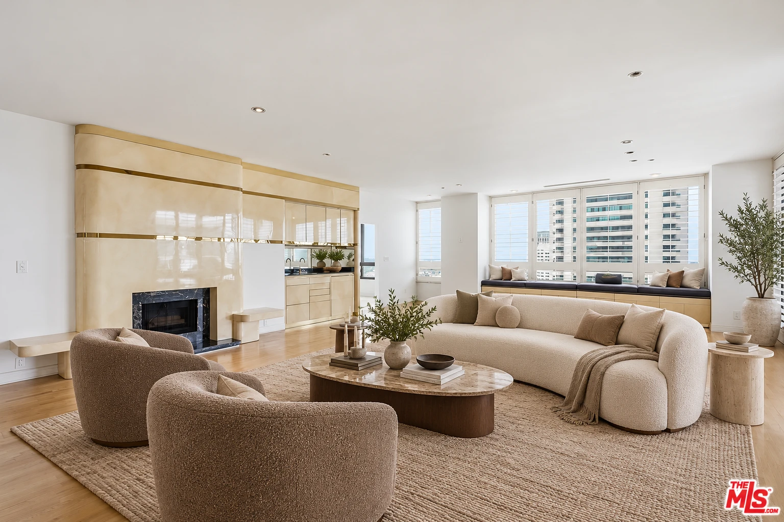 Virtually staged living room with cream seating, hardwood floors and the original fireplace